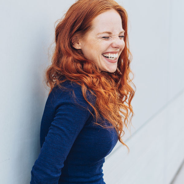 girl with red hair and blue shirt smiling