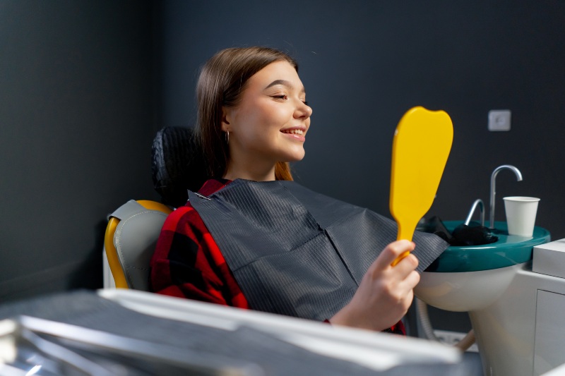 In the dental office, a girl is checking the after-results of deep dental cleaning in Wyoming, MI.